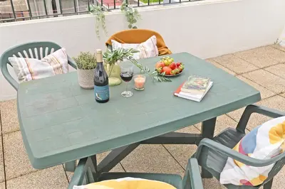a green table with a bottle of wine and a bowl of fruit at Breeze Oporto Boavista Terrace in Porto