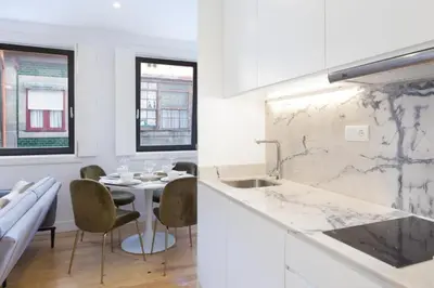 a kitchen with a sink and a table with chairs at OPorto Cosy and Modern Loft in Porto