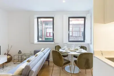 a white dining room with a table and chairs at OPorto Cosy and Modern Loft in Porto