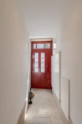 a red door in a white room with a hallway at Visconde de Gandara Apartment by Porto Stories in Porto