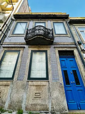 a building with two blue doors and a balcony at Hidden Gem near city center- garden, outdoor kitchen, sauna in Porto