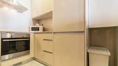 a small kitchen with white cabinets and a microwave at Adorable apartment 2D in Porto
