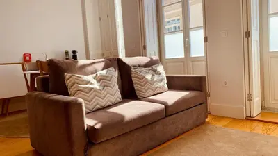 a brown couch sitting in a living room at SM Apartments in Porto