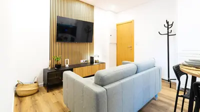 a living room with a blue couch and a table at Trendy 2BR Near Douro River by LovelyStay in Vila Nova de Gaia