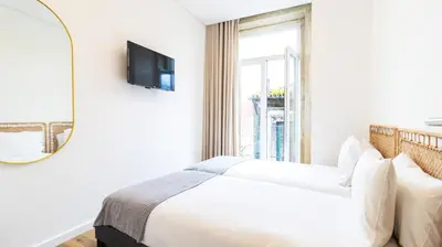 a white bedroom with a bed and a mirror at Trendy 2BR Near Douro River by LovelyStay in Vila Nova de Gaia