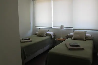 two beds in a room with two windows at My Oporto Apartment in Porto