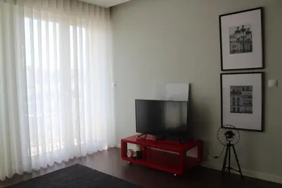 a living room with a television on a red table at My Oporto Apartment in Porto