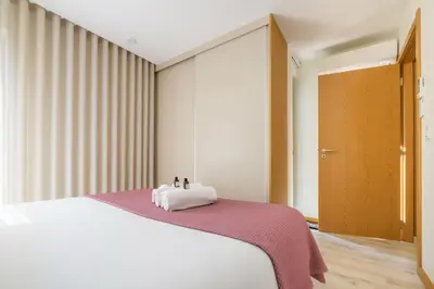 a bedroom with a white bed with a red blanket at Wonderfull apartment Campanhã Train station with parking in Porto