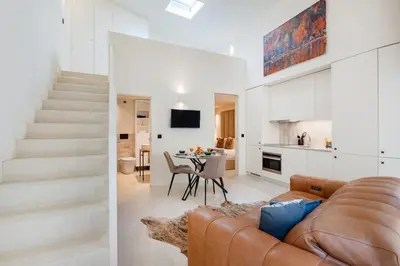 a living room and kitchen with a couch and a table at Porto Center Duplex | Edifício Terracotta in Porto