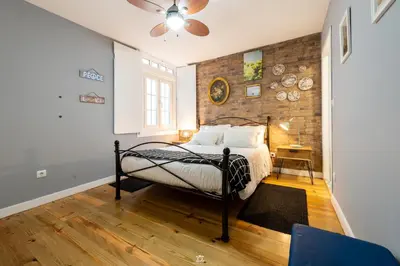 a bedroom with a bed and a brick wall at Merc Porto Downtown's Place in Porto