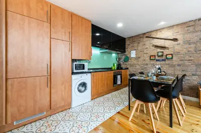 a kitchen with a table and a washing machine at Merc Porto Downtown's Place in Porto
