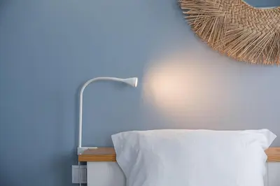 a bedroom with a blue wall with a bed and a lamp at GuestReady - Souto Downtown Studios in Porto