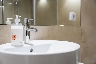 a bathroom sink with a bottle of soap on it at GuestReady - Souto Downtown Studios in Porto
