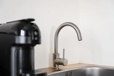 a kitchen sink with a faucet next to a coffee maker at GuestReady - Souto Downtown Studios in Porto