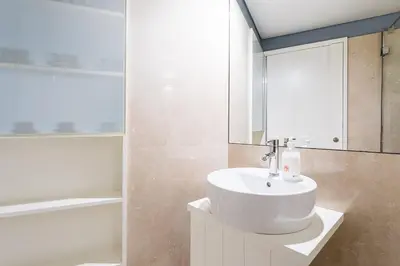 a bathroom with a white sink and a bath tub at GuestReady - Souto Downtown Studios in Porto