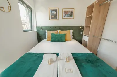 a small bedroom with a bed with a green headboard at Lapa Stylish Apartments by Vacationy in Porto
