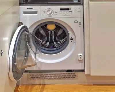 a washing machine with its door open in a kitchen at Porto Trindade Balcony in Porto