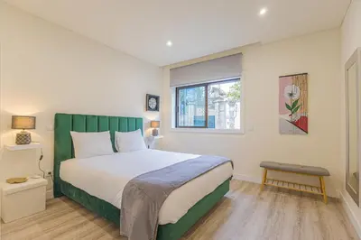 a bedroom with a large bed and a window at Marilia's Garden Apartment in Porto