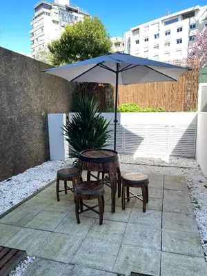 a table and two chairs and an umbrella at Marilia's Garden Apartment in Porto