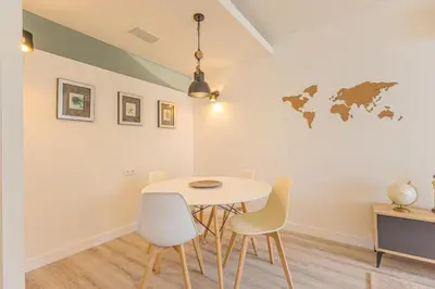 a dining room with a white table and chairs at Marilia's Garden Apartment in Porto