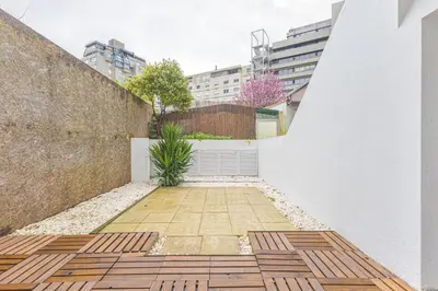 a courtyard of a house with a white wall at Marilia's Garden Apartment in Porto