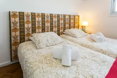 a bedroom with two beds with white sheets and pillows at Apartamento Vintage 1 in Porto