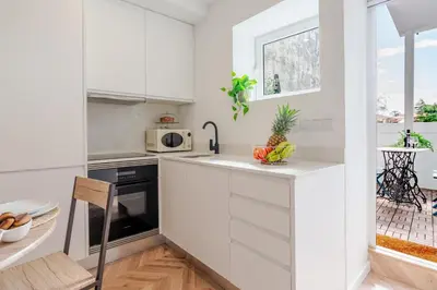 a white kitchen with a sink and a microwave at Stylish Studio w/ Charming Terrace by HostWise in Porto