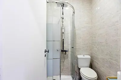 a bathroom with a toilet and a glass shower at Coliseu Downtown Loft in Porto