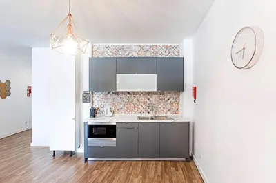 a kitchen with a sink and a clock on the wall at Coliseu Downtown Loft in Porto