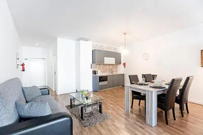 a living room with a couch and a table with chairs at Coliseu Downtown Loft in Porto
