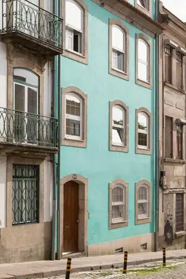 a blue building with windows and a door at A House With A View - 1st floor in Porto