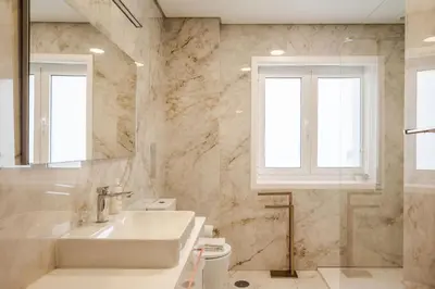 a bathroom with a sink and a toilet and windows at Family Porto in Porto