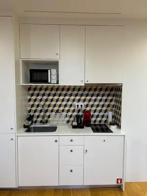 a kitchen with white cabinets and a microwave at Lazarus View Apartment in Porto