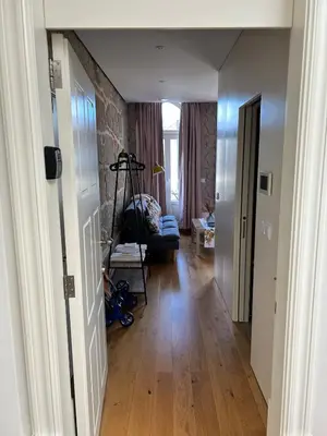 a hallway leading to a living room with wood floors at Lazarus View Apartment in Porto