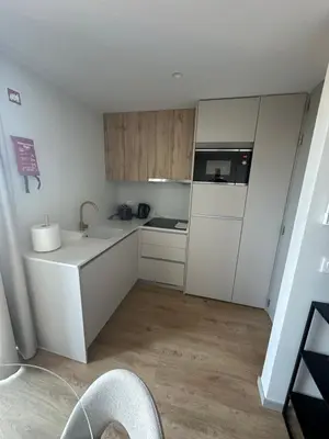 a small kitchen with white cabinets and a sink at New Douro 908 with parking in Vila Nova de Gaia
