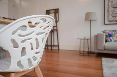 a white chair in a living room with a couch at Liiiving in Porto - Downtown & Riverside Balcony in Porto