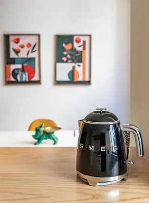 a black tea kettle sitting on a wooden table at Yellow Breeze Apartment by Cozy Stay in Porto