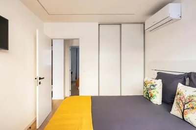 a bedroom with a king sized bed with a yellow blanket at Yellow Breeze Apartment by Cozy Stay in Porto