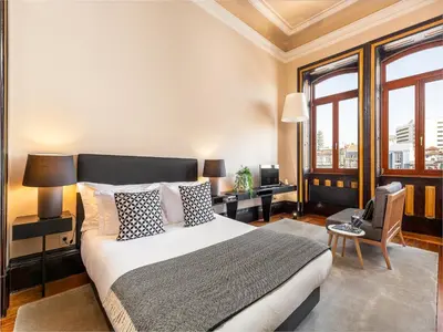 a bedroom with a king sized bed and windows at Studio near Ribeira do Porto in Porto