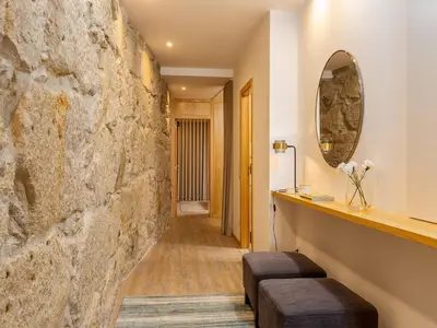 a hallway with a stone wall and a mirror at City Apartment with River Views in Vila Nova de Gaia