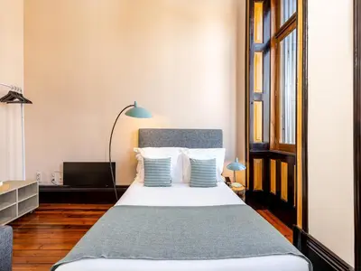 a bedroom with a bed with blue and white pillows at Centrally located apartment in Oporto in Porto