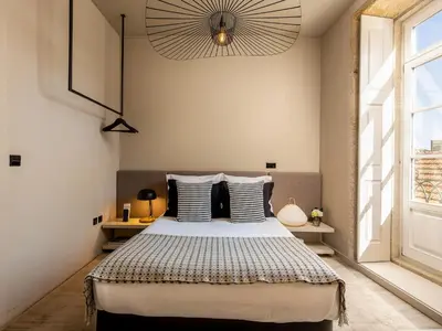 a bedroom with a bed and a large window at Apartment near picturesque Ribeira do Porto in Porto