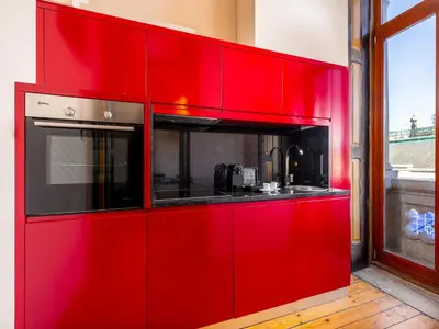 a red cabinet with a microwave in a kitchen at Cosy apartment in heart of Porto in Porto