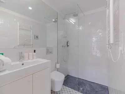 a white bathroom with a shower and a toilet at Modern studio in Porto with balcony in Porto