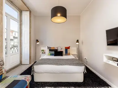 a bedroom with a large bed and a window at Studio with balcony in Oporto in Porto