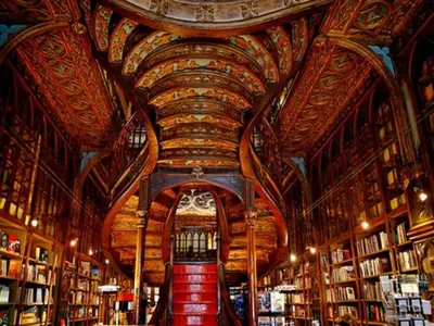 a library with a large ceiling with bookshelves at Cozy Urban apartment in Porto in Porto