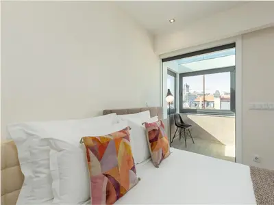 a bedroom with a white bed with pillows and a window at Spacious 4-Bedroom Apartment in Porto in Porto
