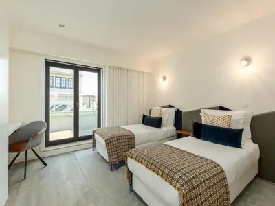 a hotel room with two beds and a window at Spacious 4-Bedroom Apartment in Porto in Porto