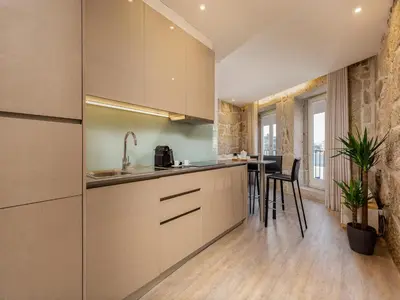 a kitchen with white cabinets and a table with chairs at Apartment in Vila Nova de Gaia in Vila Nova de Gaia