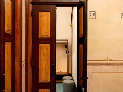 an open wooden door in a room with a mirror at Well-maintained air conditioned studio in Porto in Porto